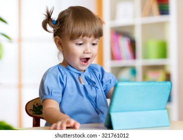 Child Girl Playing With A Digital Tablet At Home