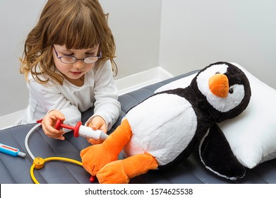 Child girl playing doctor with a toy. Rescuing of endangered animals.  Profession and care concept. Clear neutral background.