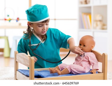 Child girl playing with dolls in the hospital.