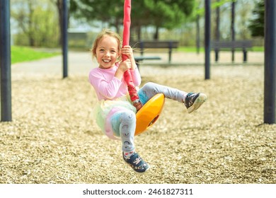 A Child girl, Playing on Playground in spring time - Powered by Shutterstock