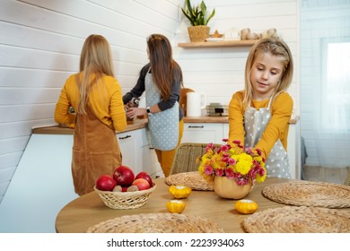 Child Girl Puts A Bouquet Of Flowers On The Dining Table. Family Prepare For Thanksgiving Dinner. Autumn Holiday.