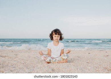 Child Girl Sitting On A Beach Meditating , Doing Yoga, Relax Mindful Breathing