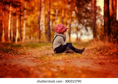 Child Girl Sitting On The Road In Autumn Country Side