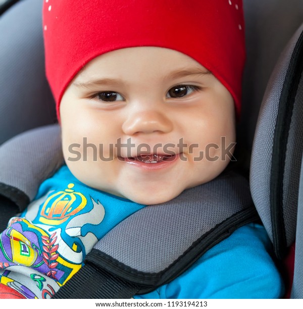Child girl sitting in a safety car seat. Safety\
and security concept