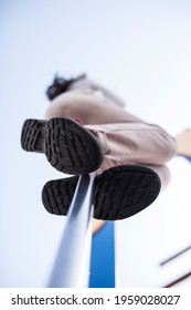 Child Girl Sliding Down By Fireman Pole Of Playground. Low Angle View