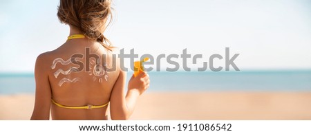 Child girl smears sun cream on her face. Selective focus. People.