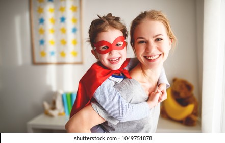 child girl in a super hero costume with mask and red cloak  at home