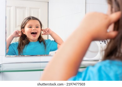 Child Girl Teasing Reflection In Bathroom Mirror