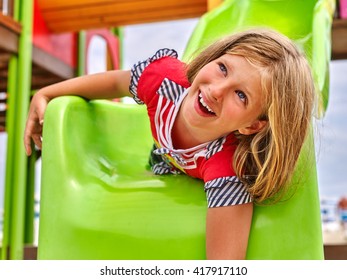 Child Girl Upside Down On Park Playground Game. Slippery Dip Girl.