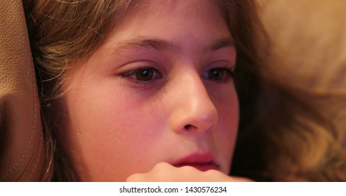 Child Girl Watching Movie Closeup Of Kid Face Absorbed By Screen Content At Home