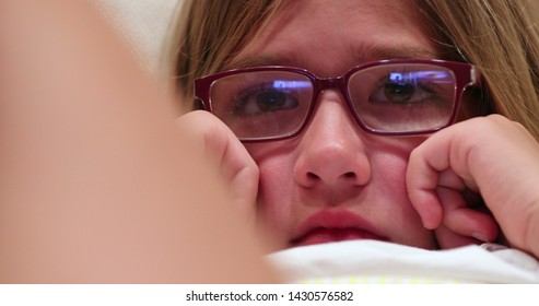 Child Girl Watching Movie Closeup Of Kid Face Absorbed By Screen Content At Home