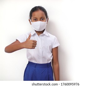 Child Girl Wearing Mask With School Uniform Doing Thumb Up. Isolated White Background.