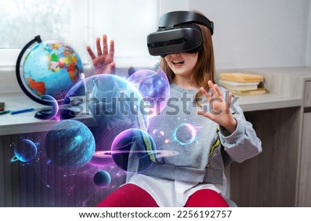 Child girl wearing virtual reality headset and looking at digital space system with planets or Universes. Space exploration with augmented reality glasses.