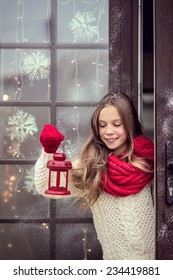 Kindermädchen willkommen Gäste und hält FeriLaterne, Schnee Wetter, Haus ist vor Weihnachten geschmückt