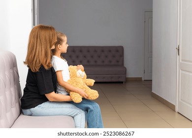 Child girl with a woman mother in the clinic, waiting for a doctor appointment. Mom with a daughter in a modern hospital before receiving a pediatrician. Kid 6-7 year old, check up before school - Powered by Shutterstock