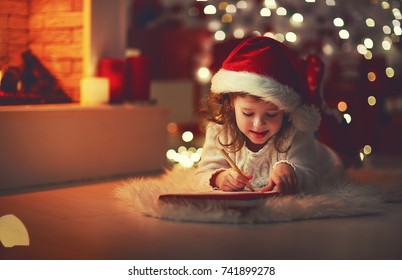Child Girl Writing Letter Santa Home Near The Christmas Tree
