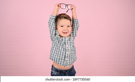 Child With Glasses, On A Pink Background. High Quality Photo