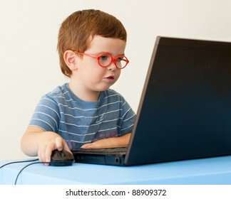 Child with glasses using computer