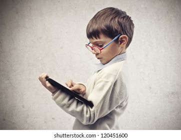 Child with glasses using a laptop computer