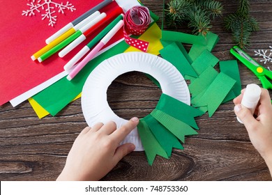 The Child Glues The Details Of The Christmas Wreath With A Candle. Made By Own Hands. Children's Art Project For Children. Craft For Kids.