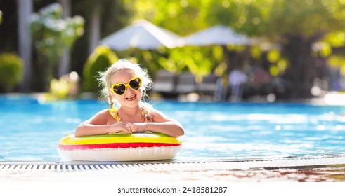 Child with goggles in swimming pool. Little girl learning to swim and dive in outdoor pool of tropical resort. Swimming with kids. Healthy sport activity for children. Sun protection. Water fun. - Powered by Shutterstock