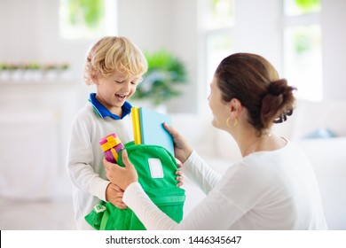 Child Going Back To School. Mother And Kid Getting Ready For First School Day After Vacation. Little Boy And Mom Going To Kindergarten Or Preschool. Student Packing Books, Apple And Lunch In Backpack.