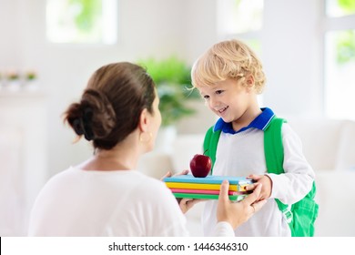 Child Going Back To School. Mother And Kid Getting Ready For First School Day After Vacation. Little Boy And Mom Going To Kindergarten Or Preschool. Student Packing Books, Apple And Lunch In Backpack.