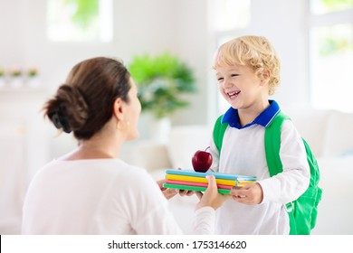 Child Going Back To School. Mother And Kid Getting Ready For First School Day After Vacation. Little Boy And Mom Going To Kindergarten Or Preschool. Student Packing Books, Apple And Lunch In Backpack.