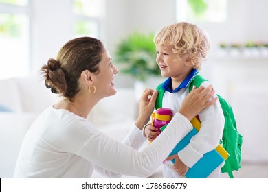 Child Going Back To School. Mother And Kid Getting Ready For First School Day After Vacation. Little Boy And Mom Going To Kindergarten Or Preschool. Student Packing Books, Apple And Lunch In Backpack.