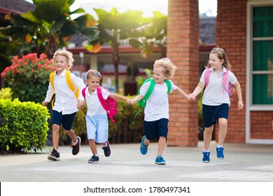 Child Going To School. Boy And Girl Holding Books And Pencils On The First School Day. Little Students Excited To Be Back To School. Beginning Of Class After Vacation. Kids Eating Apple In School Yard