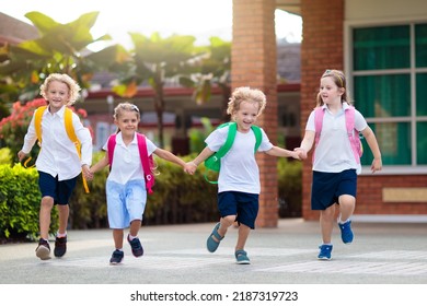 Child going to school. Boy and girl holding books and pencils on the first school day. Little students excited to be back to school. Beginning of class after vacation. Kids eating apple in school yard - Shutterstock ID 2187319723