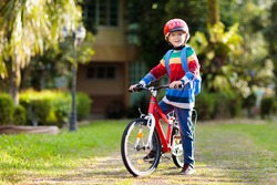 Child Going To School On Bike. Kids Ride Bicycle. Safe Way To Elementary School. Little Boy With Backpack On Red Bike Wearing Safety Helmet. Healthy Outdoor Activity For Young Student.