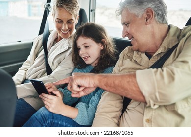 Child, grandparents and phone on road trip in car backseat streaming movie, elearning or helping with education game. Child, man and woman uber happy on travel journey and checking destination online
