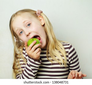 Child with green apple - healthy concept, humor