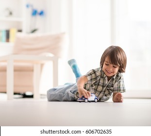 Child At Ground Playing With Car Toy