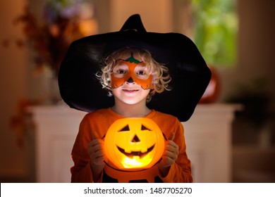 Child In Halloween Costume. Kids Trick Or Treat. Little Boy With Pumpkin Face Painting And Lantern.