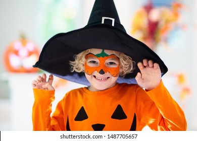 Child In Halloween Costume. Kids Trick Or Treat. Little Boy With Pumpkin Face Painting And Lantern.