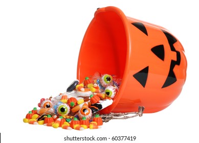 child halloween pumpkin bucket spilling candy - Powered by Shutterstock