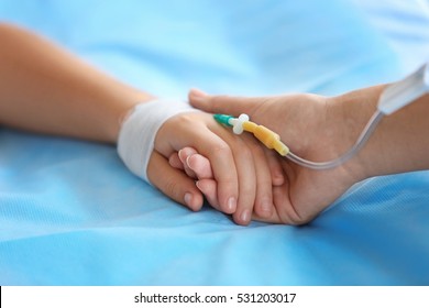 Child Hand With Catheter On Bed