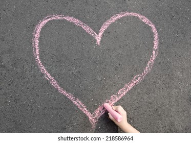 child hand drawing heart