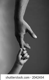 Child Hand Hold By The Adult Hand