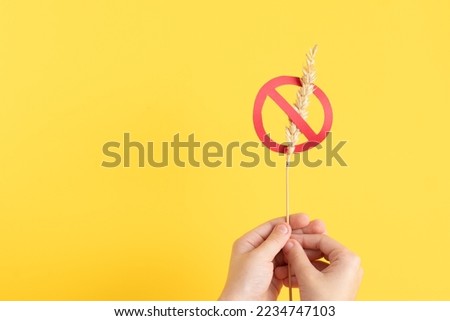 Child hand holding gluten free symbol. Celiac background 
