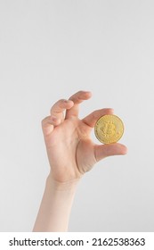 Child Hand Holding Gold Bitcoin Coin. Cryptocurrency Business Concept