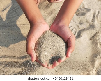 a child hand holding sands. play with white sand. - Powered by Shutterstock