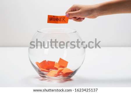 Child hand picking winner from a glass bowl, random name ballot, simple raffle