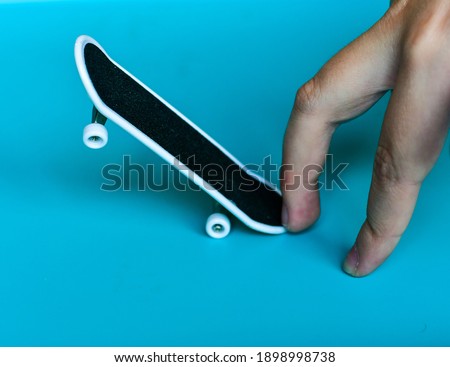 Child Hand playing  a fingerboard, close-up. Mini skate- fingerboard competitions, freestyle .