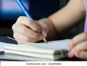 Child Hand Is Using Pencil To Practice Writing On A Book. Kid Learning To Write Letter On To A Paper, For Pre School Education Concept.