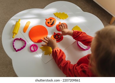 Child Hands Creating Playdough Funny And Angry Pumpkins And Autumn Leaves For The Holiday Of Halloween. Sensory Play For Toddlers. Holiday Art Activity For Kids.