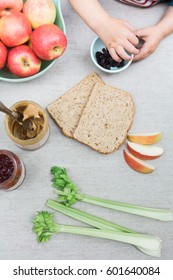 Child Hands Eating Lunch And Making A Peanut Butter And Jelly Sandwich With Celery 