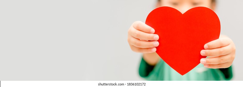 Child hands holding red heart for share Donate.Health care pediatric.family insurance.World heart day, world health day,CSR responsibility, Adoption foster kids.Worship with faith.Banner background.